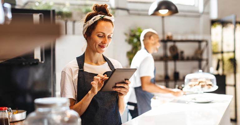 Restaurant worker smiling while holding tablet