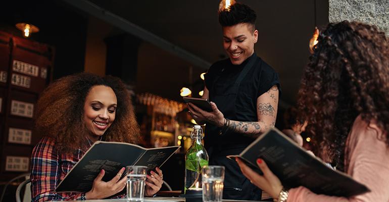 customers in a restaurant looking at a menu.jpg