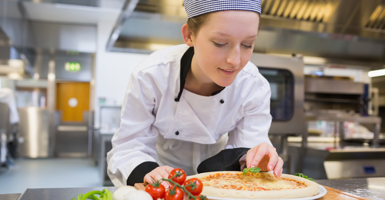 Female chef making a pizza