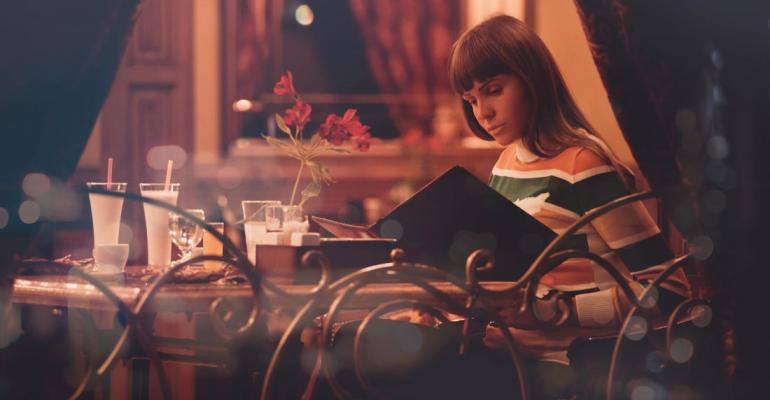 Woman looking at a restaurant menu through a window