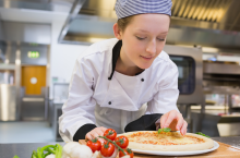 Female chef making a pizza