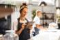 Restaurant worker smiling while holding tablet