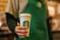 A Starbucks barista holding a cup